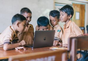 boy using silver macbook indoors