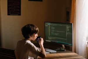 boy in white t shirt sitting on chair in front of computer